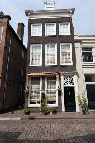 a brick house with white windows on a brick street at BenB FirstClassEnglish in Dordrecht