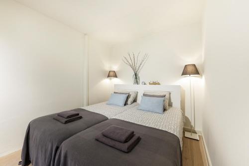 a bedroom with a large bed with two towels on it at Adam's Suite in Amsterdam