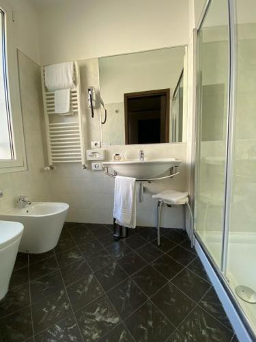 a bathroom with a tub and a sink and a shower at Card International Hotel in Rimini