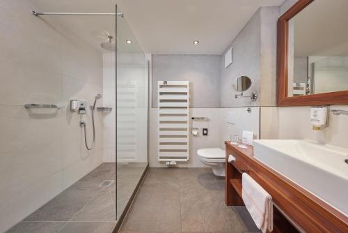 a bathroom with a shower and a toilet and a sink at Hotel Am Kamin in Kaufbeuren