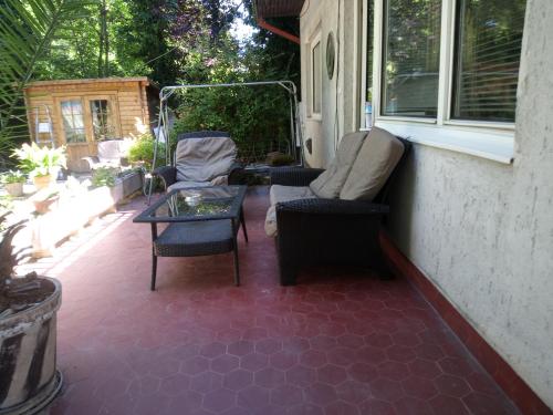 a patio with chairs and a table and a window at Balassa House in Siófok