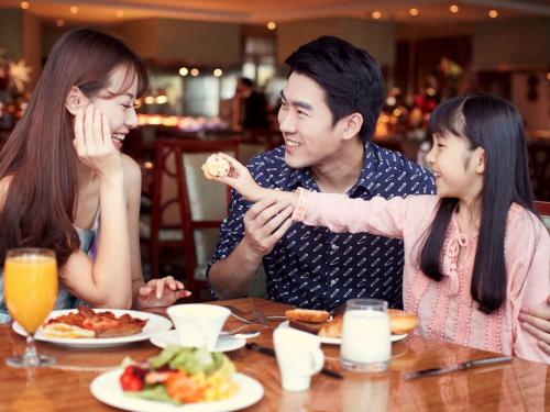 a group of people sitting at a table eating food at Fairmont Yangcheng Lake in Kunshan