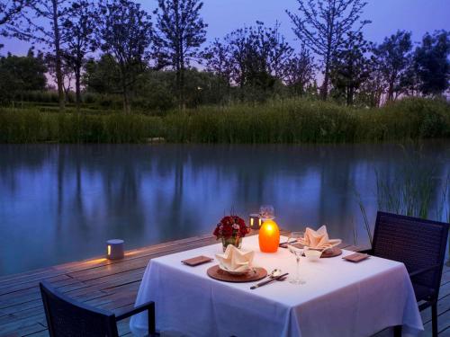 a table with a white table cloth and a candle at Fairmont Yangcheng Lake in Kunshan