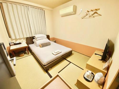徳島市にあるGuestHouse017徳島個室 飲食街中心 阿波踊り会館7分 文理&徳島大学 アスティとくしま車8分のベッドとデスクが備わる小さな客室です。