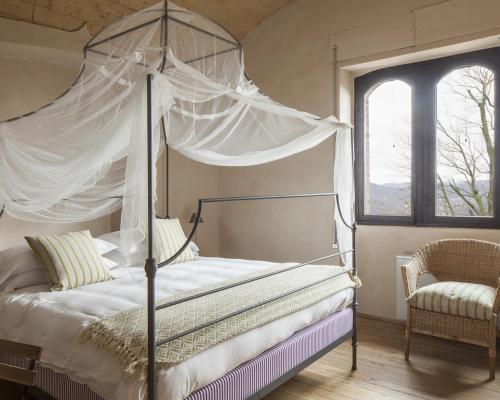 a bedroom with a canopy bed and a window at Castello di Gabiano in Gabiano