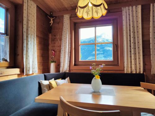a dining room with a table and a vase with flowers at Ferienwohnung Gassenhof in Matrei in Osttirol