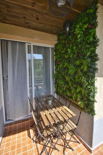 a wooden bench sitting on a porch next to a window at PMP Adamia Apartments in Peyia