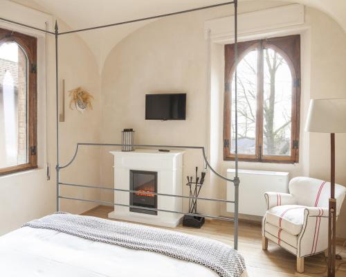 
a bedroom with a fireplace and a television at Castello di Gabiano in Gabiano
