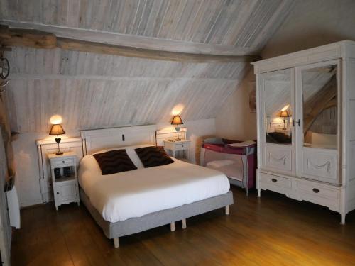 a bedroom with a white bed and two night stands at Gîte l ´écurie à la campagne in Flines-lès-Mortagne