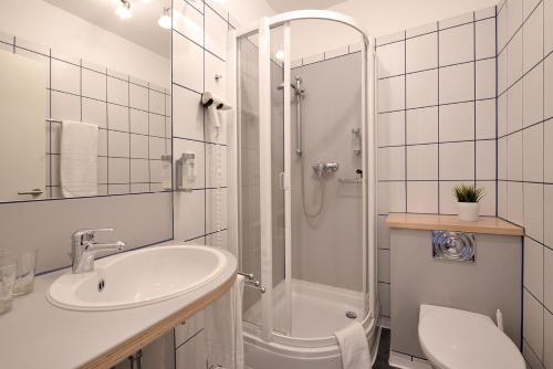 a bathroom with a sink and a shower and a toilet at Gut Funkenhof in Sundern