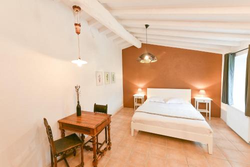 a bedroom with a bed and a table and a desk at Auberge La Plaine in Chabrillan