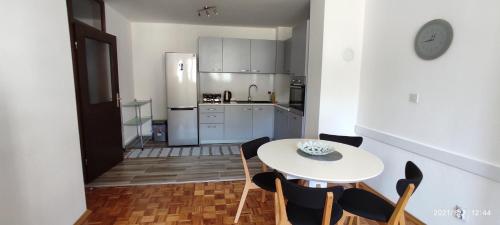 eine Küche mit einem Tisch und Stühlen sowie einem Kühlschrank in der Unterkunft Apartment Emina in Travnik