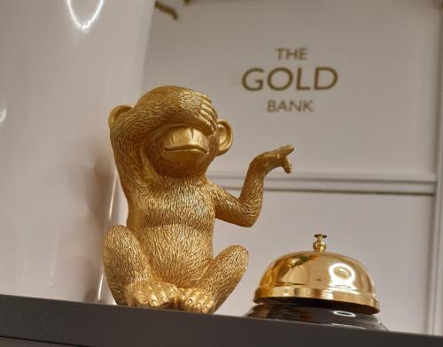 a gold monkey sitting on a shelf with a gold bank sign at The Gold Bank in Prague