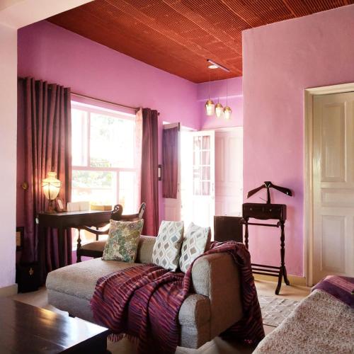 a living room with purple walls and a couch at Ranjit's Svaasa Amritsar in Amritsar