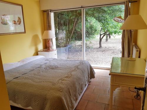 um quarto com uma cama e uma grande janela em Mas des Figues Gîte #farmstay #certifiedorganic #zeropesticide #agritourism #ecotourism #saintrémydeprovence #Alpilles em Saint-Rémy-de-Provence