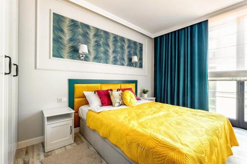 Un dormitorio con una cama amarilla y una ventana en Apartament Turkusowy, en Zamość