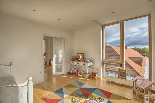 ein Wohnzimmer mit einem großen Fenster und ein Schlafzimmer in der Unterkunft OpaKopa in Klaipėda