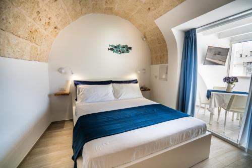 ein Schlafzimmer mit einem großen Bett in einem Zimmer in der Unterkunft Vico Blu in Polignano a Mare