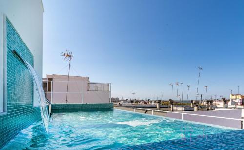 a swimming pool on the side of a building at Apartamentos luxury Doña Bella 2a in Ayamonte