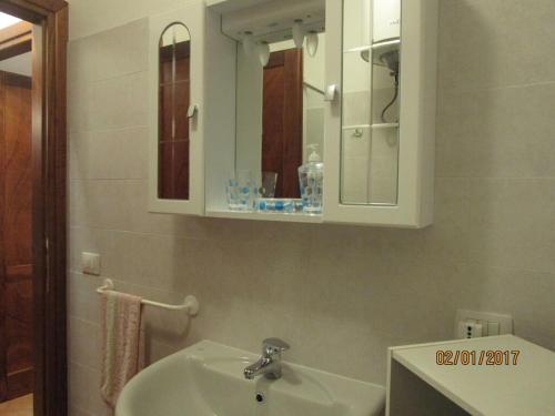 een badkamer met een wastafel en een spiegel bij Appartamento con vista meravigliosa in Castelsardo