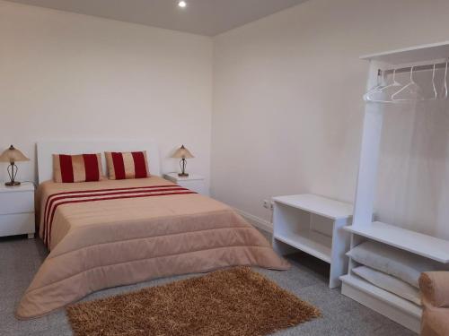 een witte slaapkamer met een bed en twee nachtkastjes bij Arrivillage in Arrifes