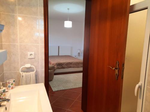 een badkamer met een wastafel, een toilet en een spiegel bij Arrivillage in Arrifes
