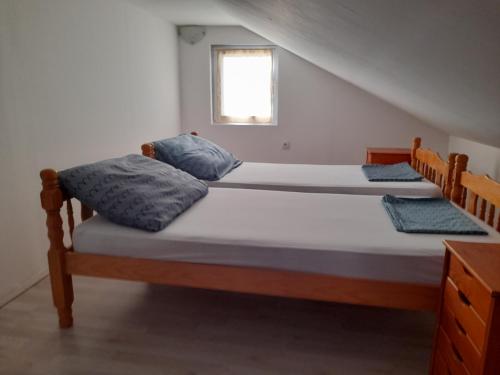two twin beds in a room with a window at Apartmani Goga in Pirovac