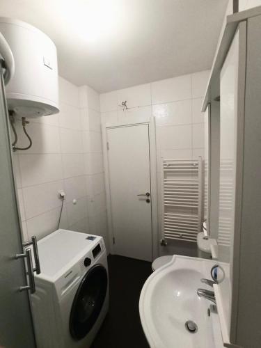 a bathroom with a sink and a washing machine at Apartman CITY CENTER 1-šetalište in Prijedor