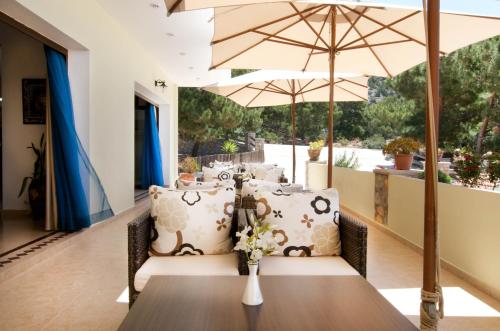 a dining room with a table and umbrella at Miraluna Aparthotel in Lefkos Karpathou