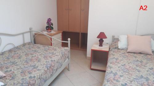 een slaapkamer met 2 bedden en een tafel met een lamp bij Kamena kuca Smiljevac - Stone house Apartment 2 in Ližnjan