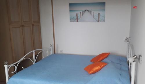 een slaapkamer met een blauw bed met 2 oranje kussens bij Kamena kuca Smiljevac - Stone house Apartment 2 in Ližnjan