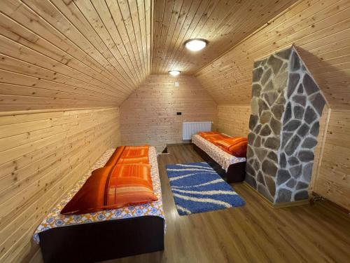 Habitación con 2 camas en una cabaña de madera en Balu, en Borzont