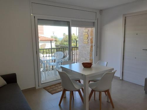 a dining room with a table and chairs and a balcony at Apartamentos Dins Mar Apto. 1 in Torredembarra