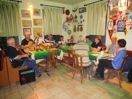 grupa ludzi siedzących przy stołach grających muzykę w obiekcie Penzion Braun w mieście Rybniště
