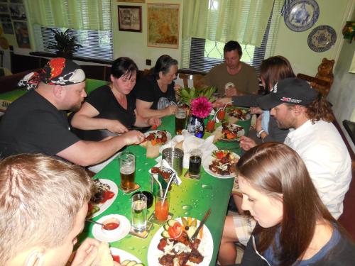 a group of people sitting around a table eating food at Penzion Braun in Rybniště