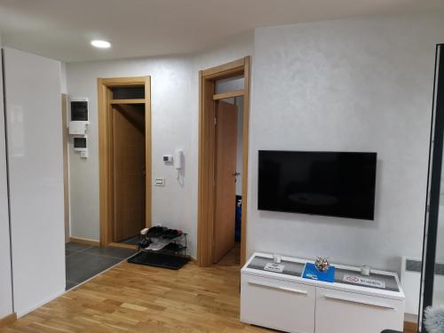 Una sala de estar con un televisor de pantalla plana en una pared. en Vila Marija Zlatibor - Apartman 2, en Zlatibor