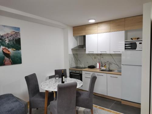 Vila Marija Zlatibor - Apartman 2 في زلاتيبور: مطبخ مع طاولة وكراسي في غرفة