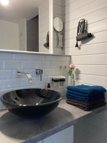 a bathroom with a black sink and a mirror at Living at Saarpartments - AdultsOnly - Business & Holiday Homes with Kitchen for Long- and Short Term stay, 3 min to St Johanner Markt and Points of Interest in Saarbrücken