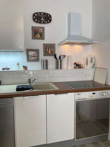 a kitchen with white cabinets and a sink at Living at Saarpartments - AdultsOnly - Business & Holiday Homes with Kitchen for Long- and Short Term stay, 3 min to St Johanner Markt and Points of Interest in Saarbrücken