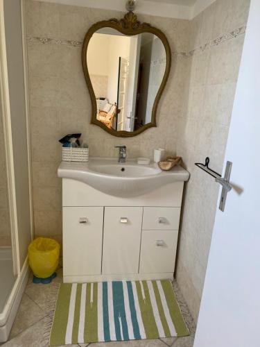 een badkamer met een wastafel en een spiegel bij “Da Senso” Relax nel verde vista mare in Finale Ligure