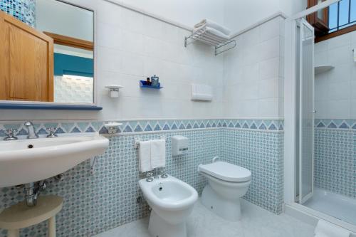 a bathroom with a toilet and a sink at Hotel Sicilya in San Vito lo Capo