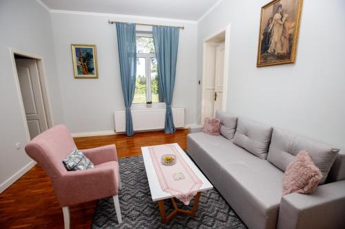 a living room with a couch and a table at Angeli Vila Apartments in Subotica