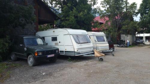 a camper and a truck parked next to a house at Camping Aviator Busteni, Parcare rulota termen lung (6-12 luni). in Buşteni