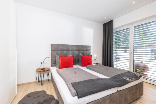 um quarto com uma cama grande e almofadas vermelhas em Apart Sabrina Fügen em Fügen