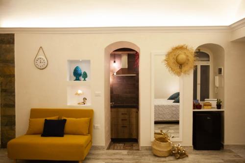 salon z żółtą kanapą i sypialnią w obiekcie Plebiscito House - Casa Vacanze Napoli w mieście Neapol