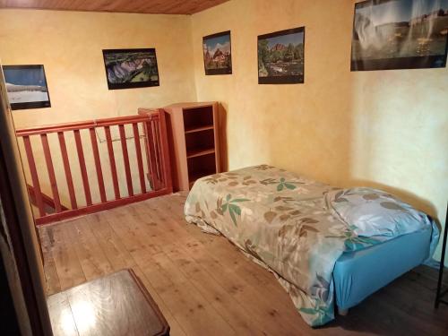 Un pequeño dormitorio con una cama y una escalera en Gite familial à proximité d'une mini ferme en Saint-Haon