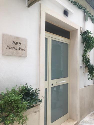 eine Tür mit einem Schild an der Seite eines Gebäudes in der Unterkunft B&B PIETRA VIVA in Sannicandro di Bari