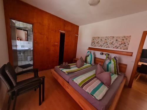 1 Schlafzimmer mit 2 Betten, einem Stuhl und einem Waschbecken in der Unterkunft Ferienwohnungen Ödenburgerhof in Mörbisch am See