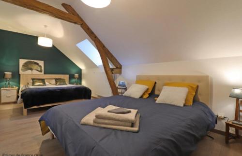 une chambre avec un grand lit avec des serviettes dessus dans l'établissement Domaine du clos henri, à Essay