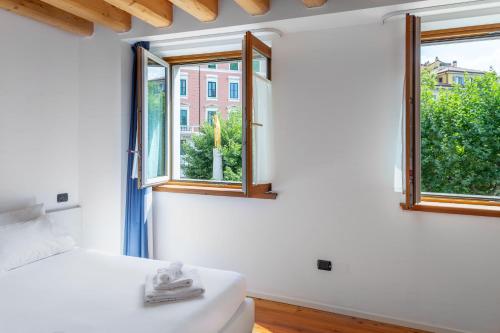 a bedroom with a bed and two windows at Residence Garibaldi in Trieste